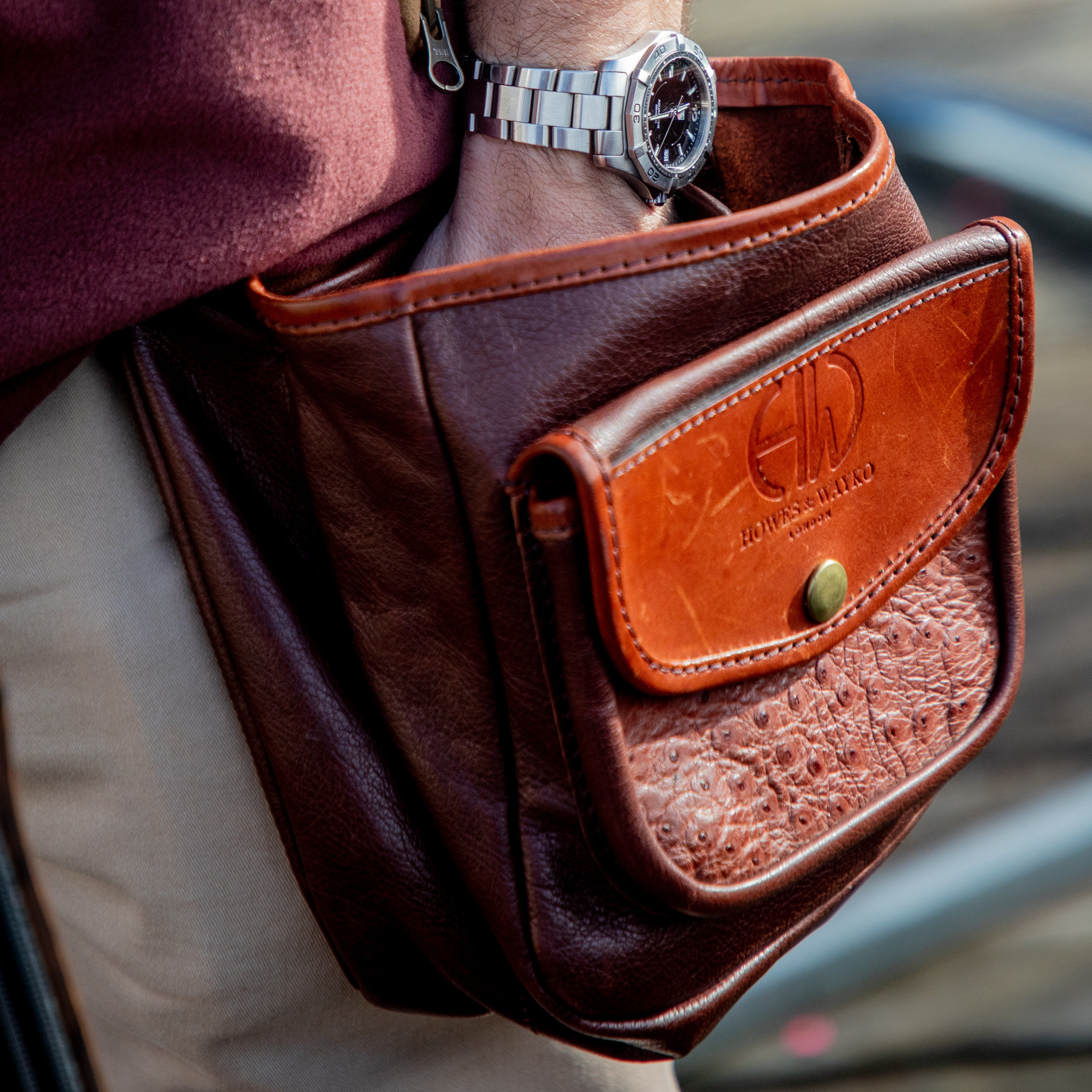 shotgun cartridge pouch, person has their hand in the leather pouch