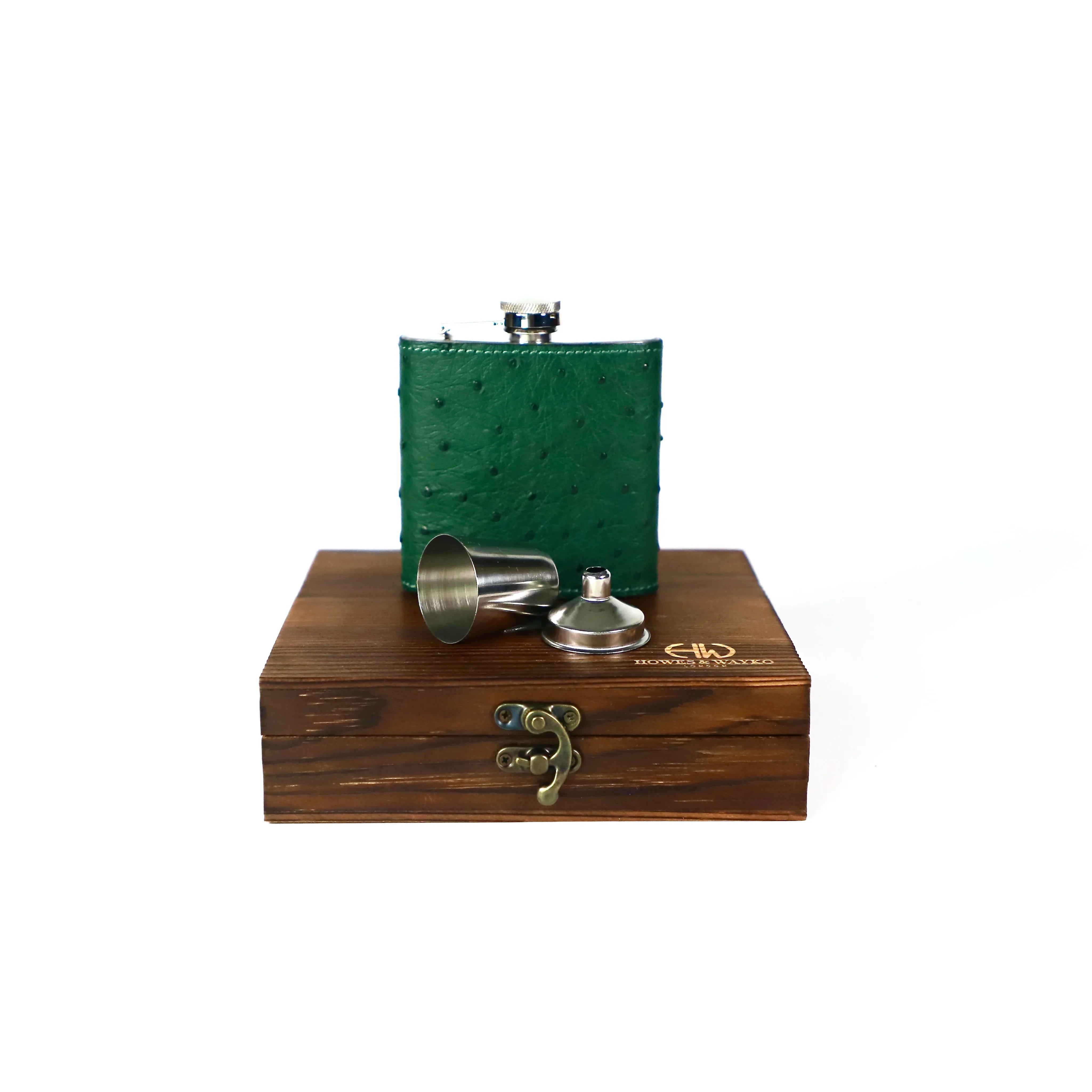 6oz stainless steel flask, covered in green Ostrich leather. Displayed on a wooden gift box and has a white background.