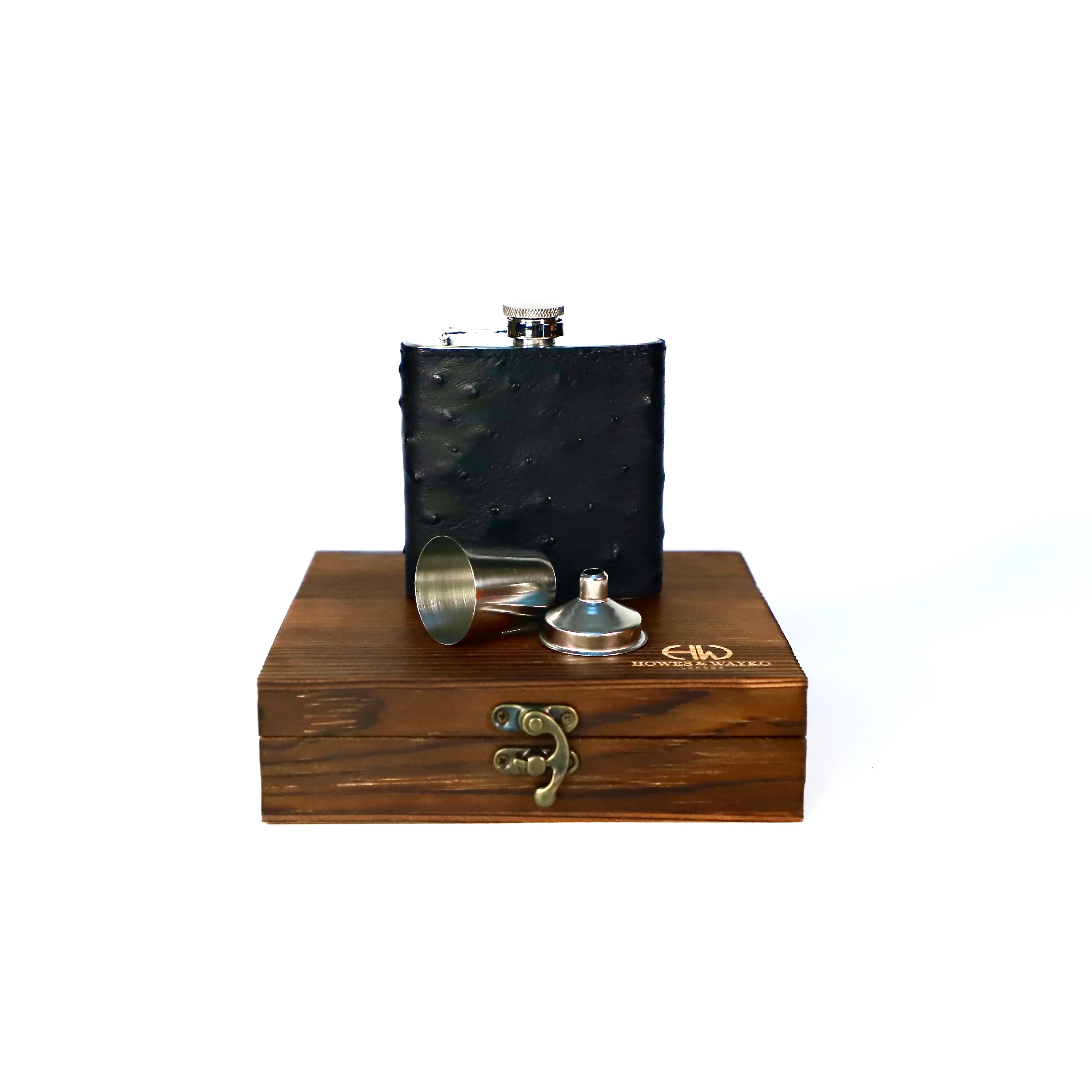 Black Stainless steel flask with black Ostrich leather, displayed on a wooden box with a brass latch against a white background