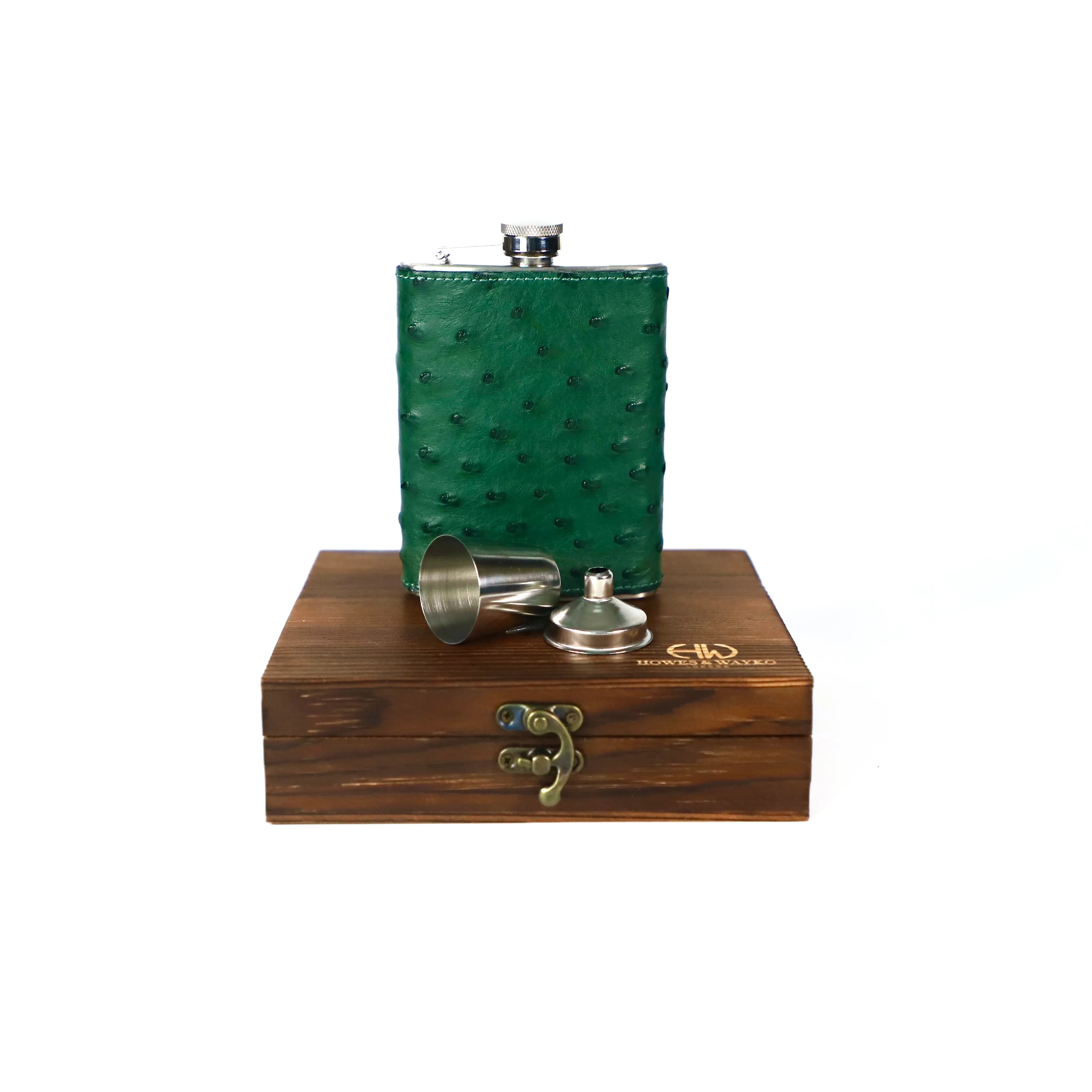 stainless steel hip flask, covered with green Ostrich leather, displayed on a brown wooden gift box displayed with a white background.
