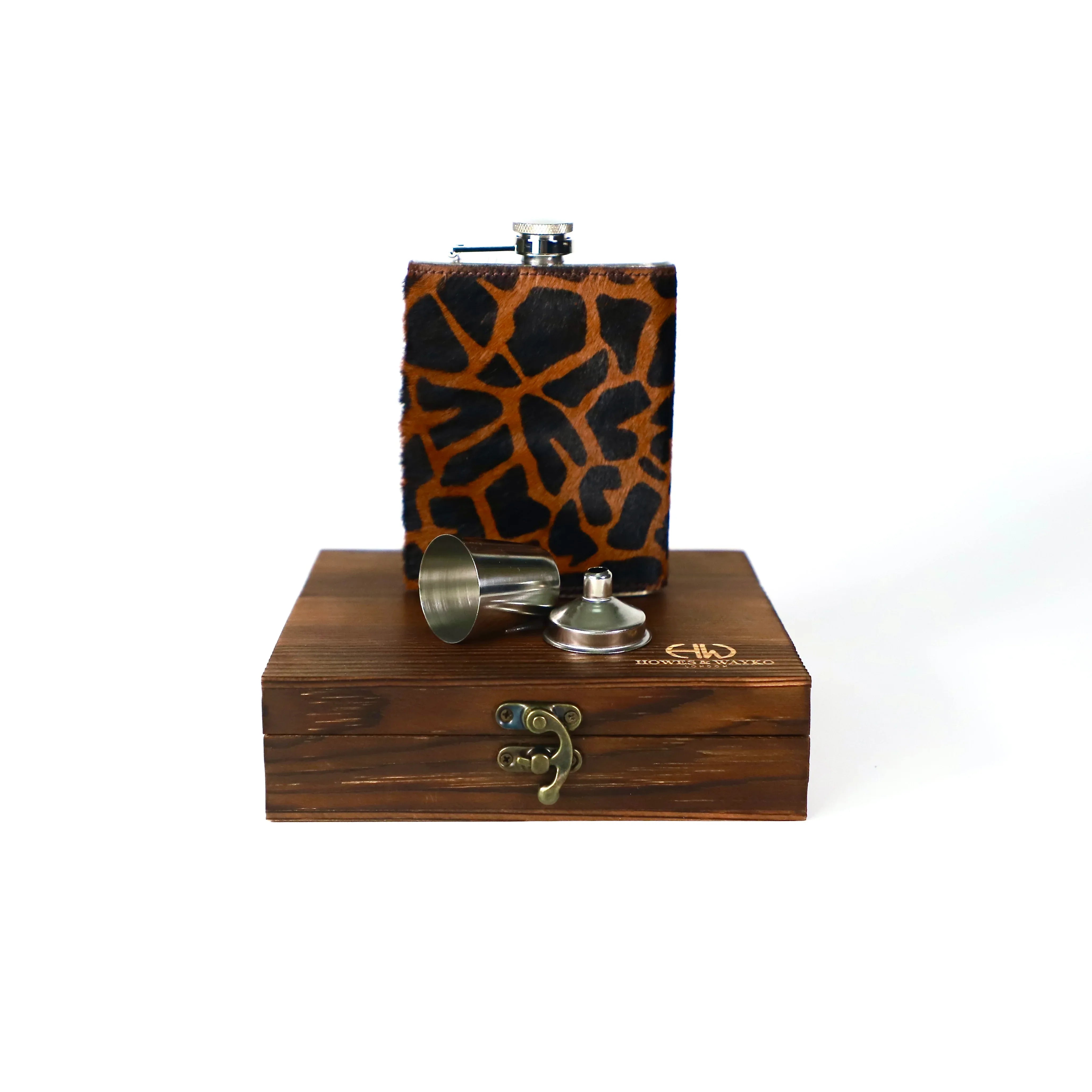Flask with giraffe pattern cover and wooden box on a white background