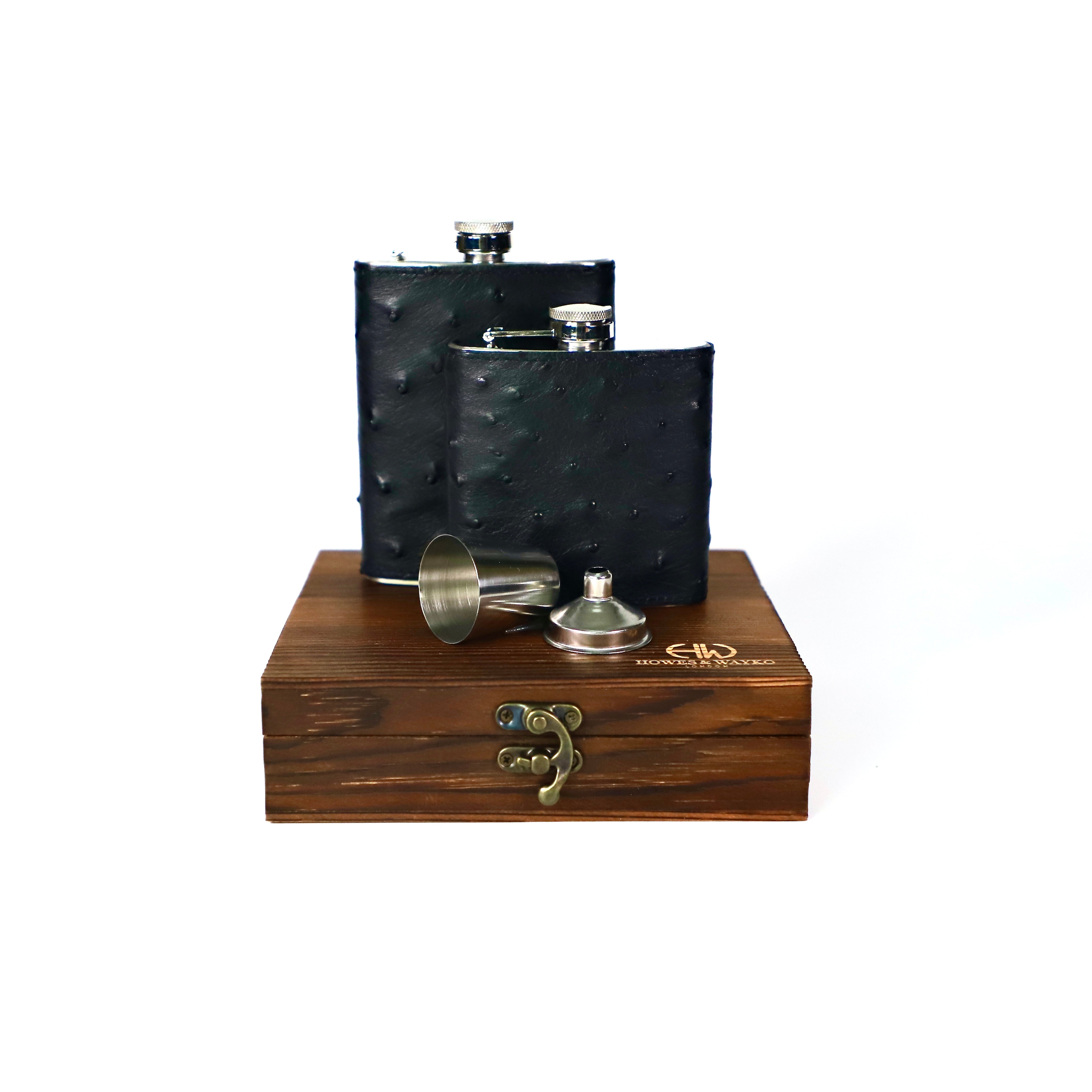 Black leather Ostrich leather flask set with a wooden box on a white background