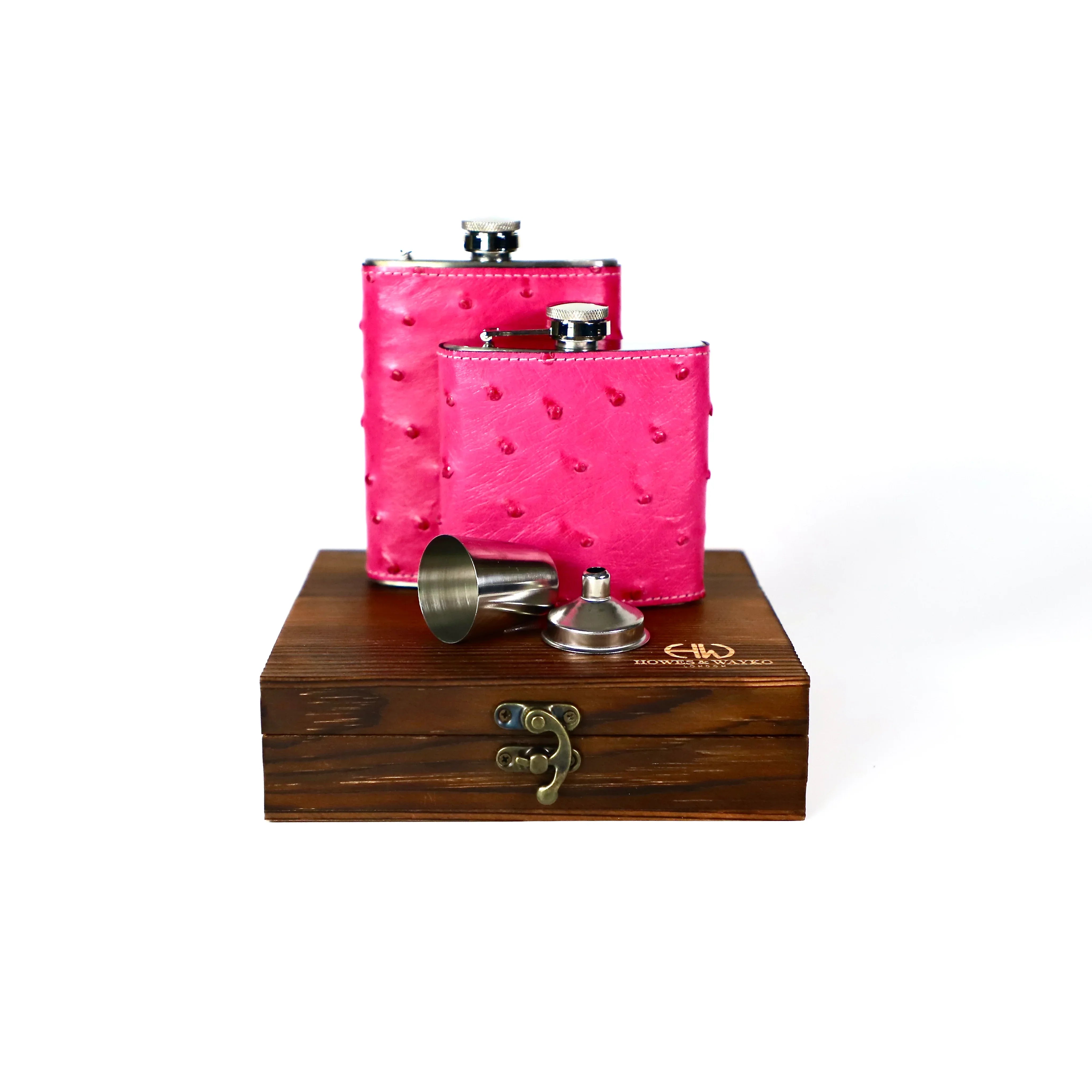 Two flasks covered in pink Ostrich skin are displayed on top of a wooden gift box on a white background