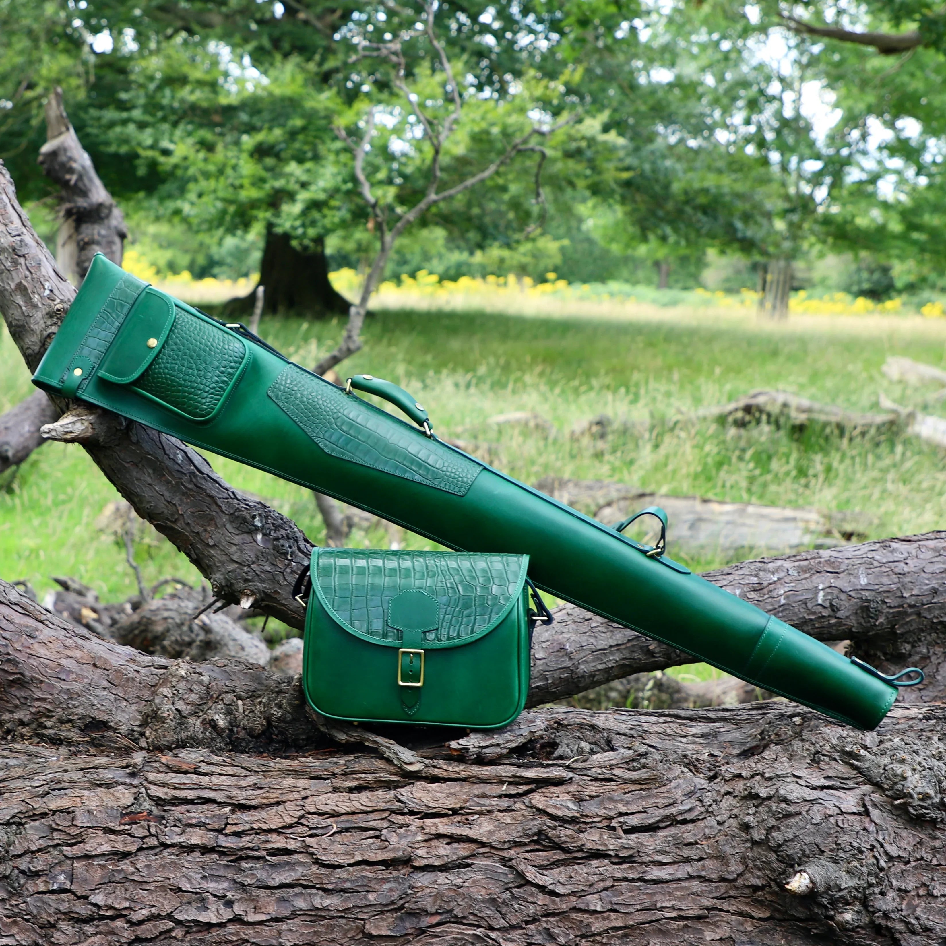 gun slip in green with matching mock crocodile skin. It features a luxurious sheepskin lining, a substantial outer pocket and eye-catching brass hardware with woodland background