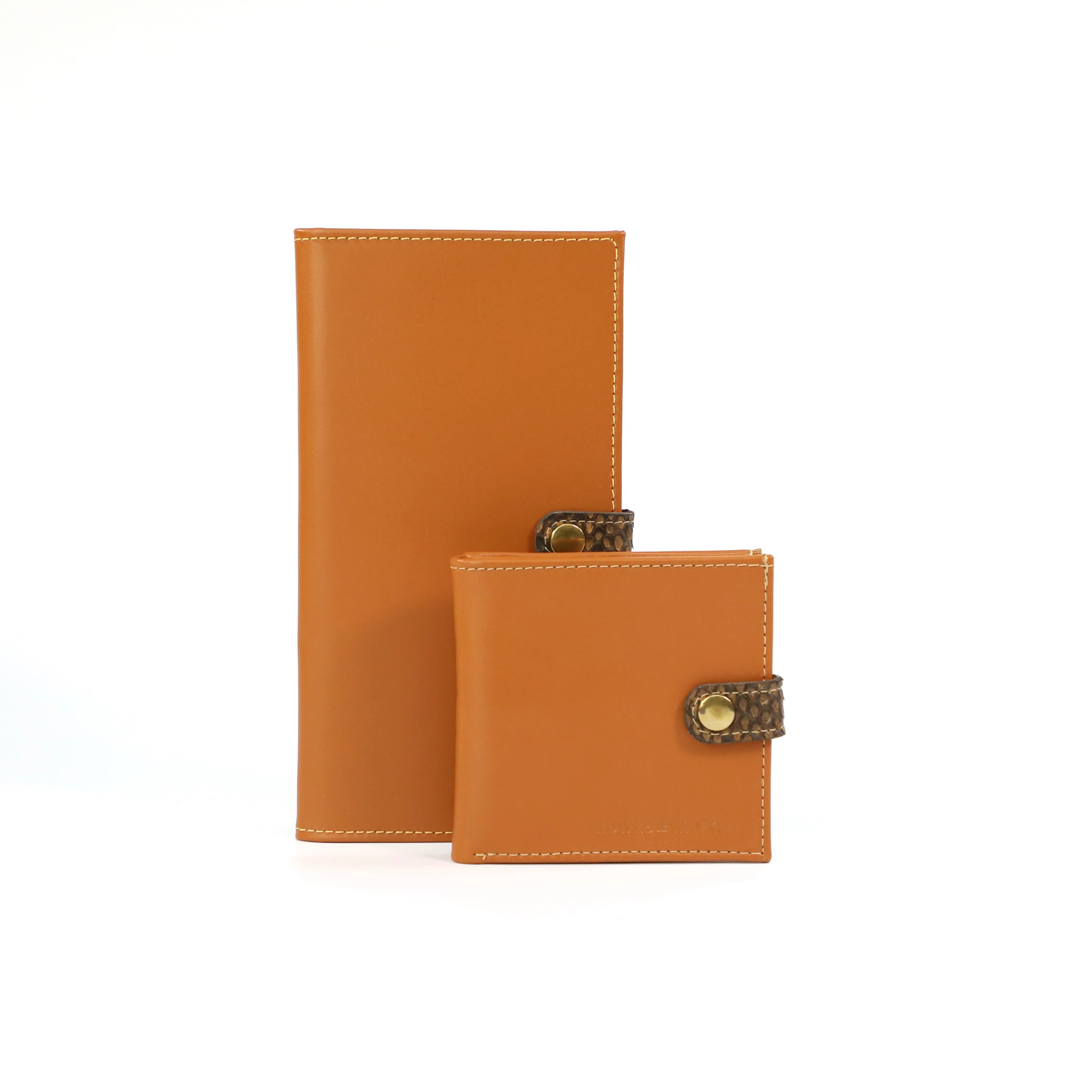 Two mustard leather certificate wallets with decorative clasps on a white background