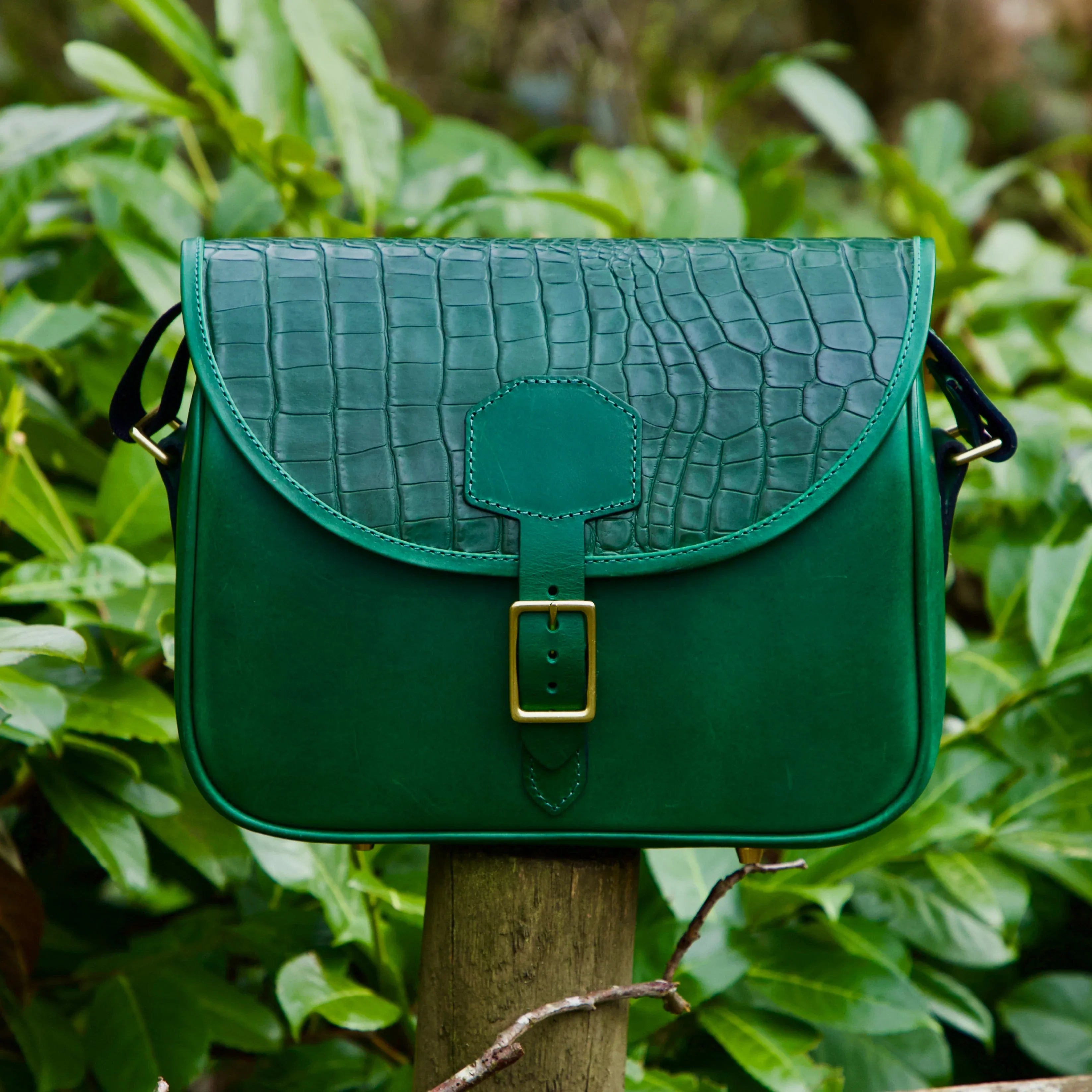 another version of the mock croc cartridge bag in green shot taken outdoors