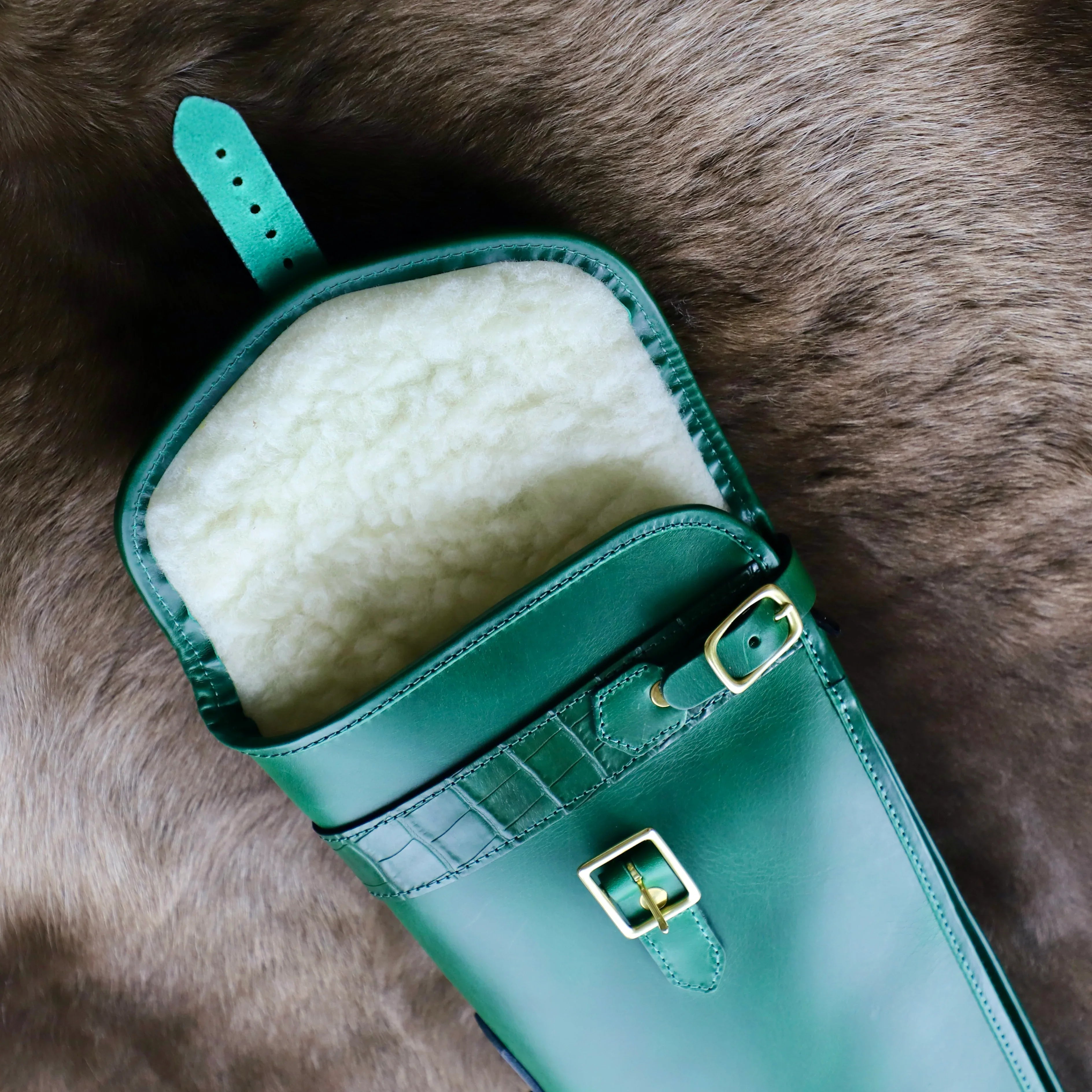gun slip in green with matching mock crocodile skin. Close up of luxurious sheepskin lining, a substantial outer pocket and eye-catching brass hardware interior