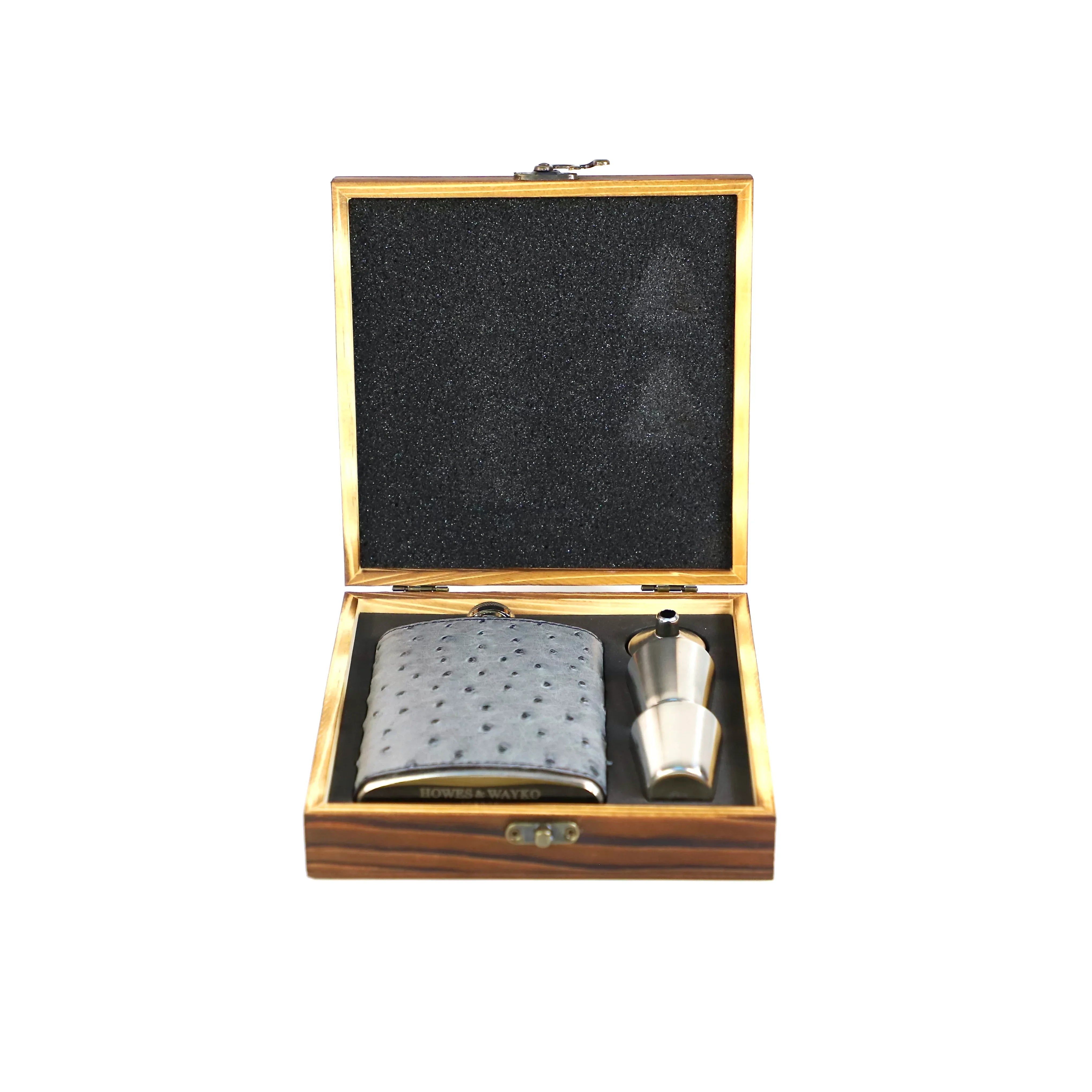 Flask and shot glass set in a wooden box on a white background