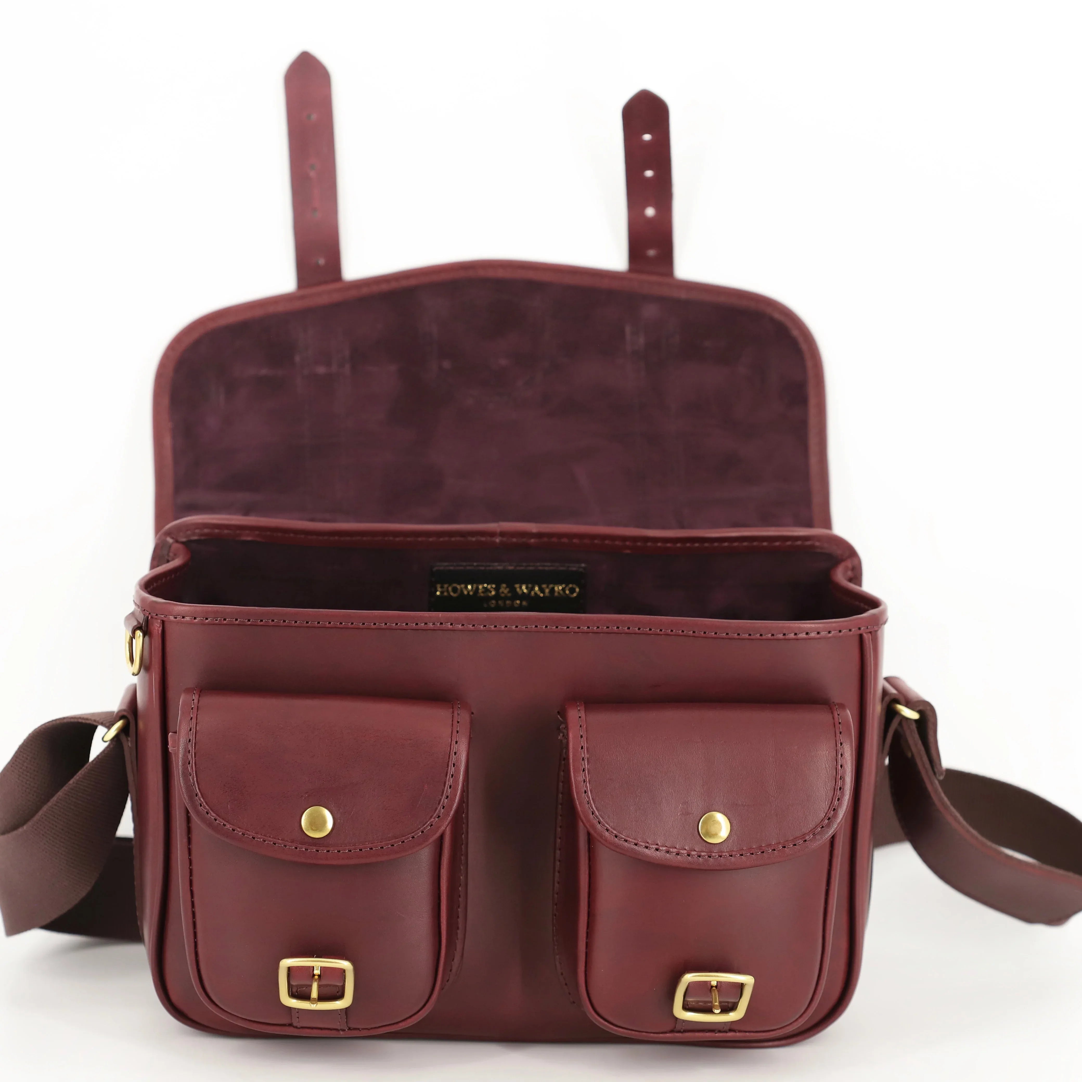 classic style leather range bag front view with front pockets with unlatched brass buckles open top
