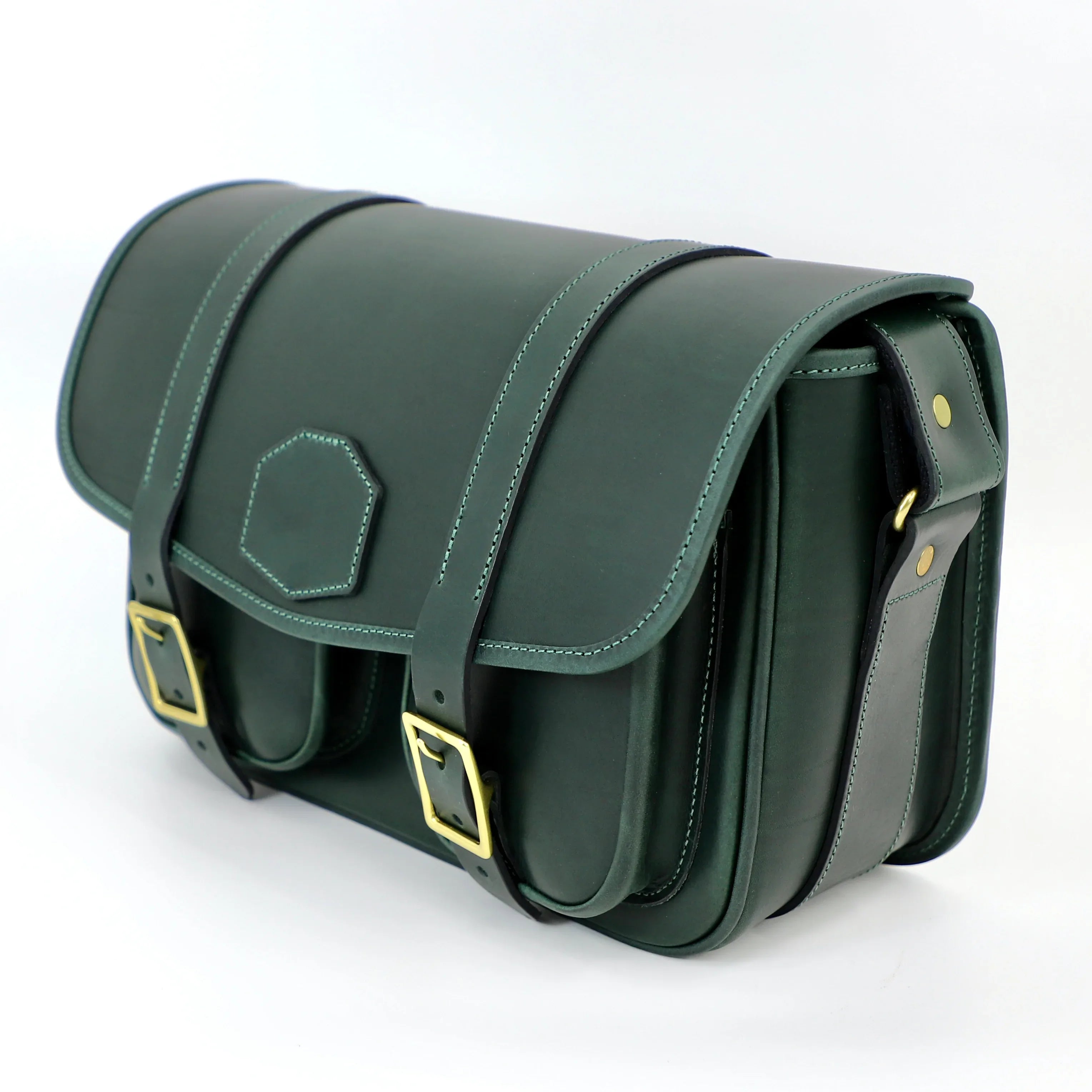 side view of green range bag with brass buckles and closed front flap