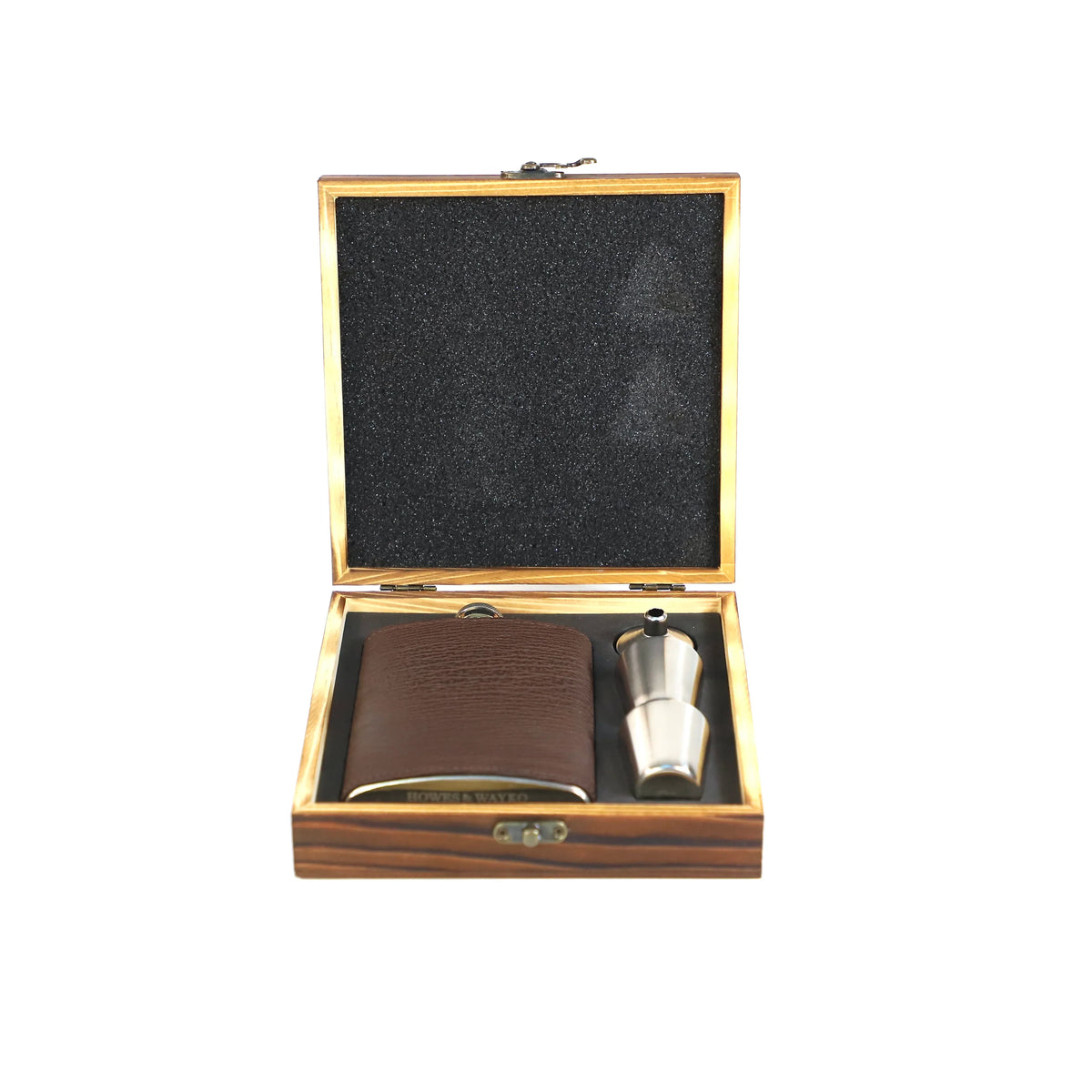 Wooden box with a brown leather whisky flask, with a stainless steel funnel and a shot glass on a white background