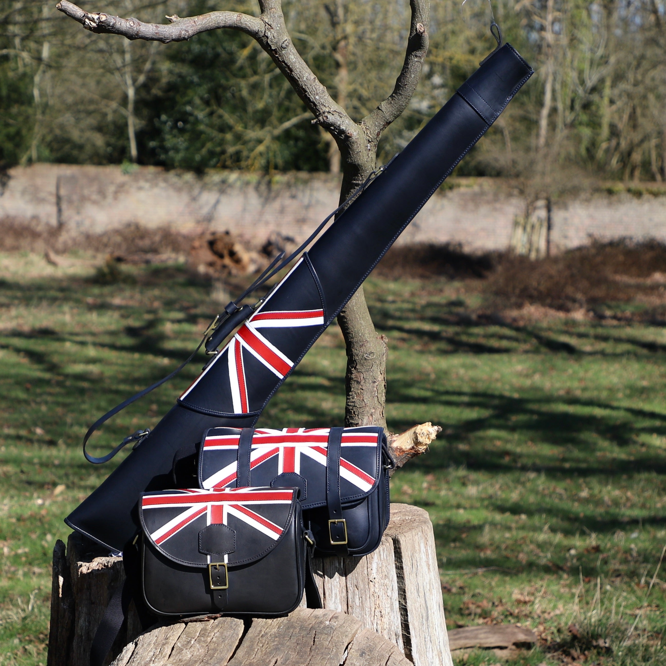 navy leather bag and range slip with Union Jack design on a wooden log outdoors