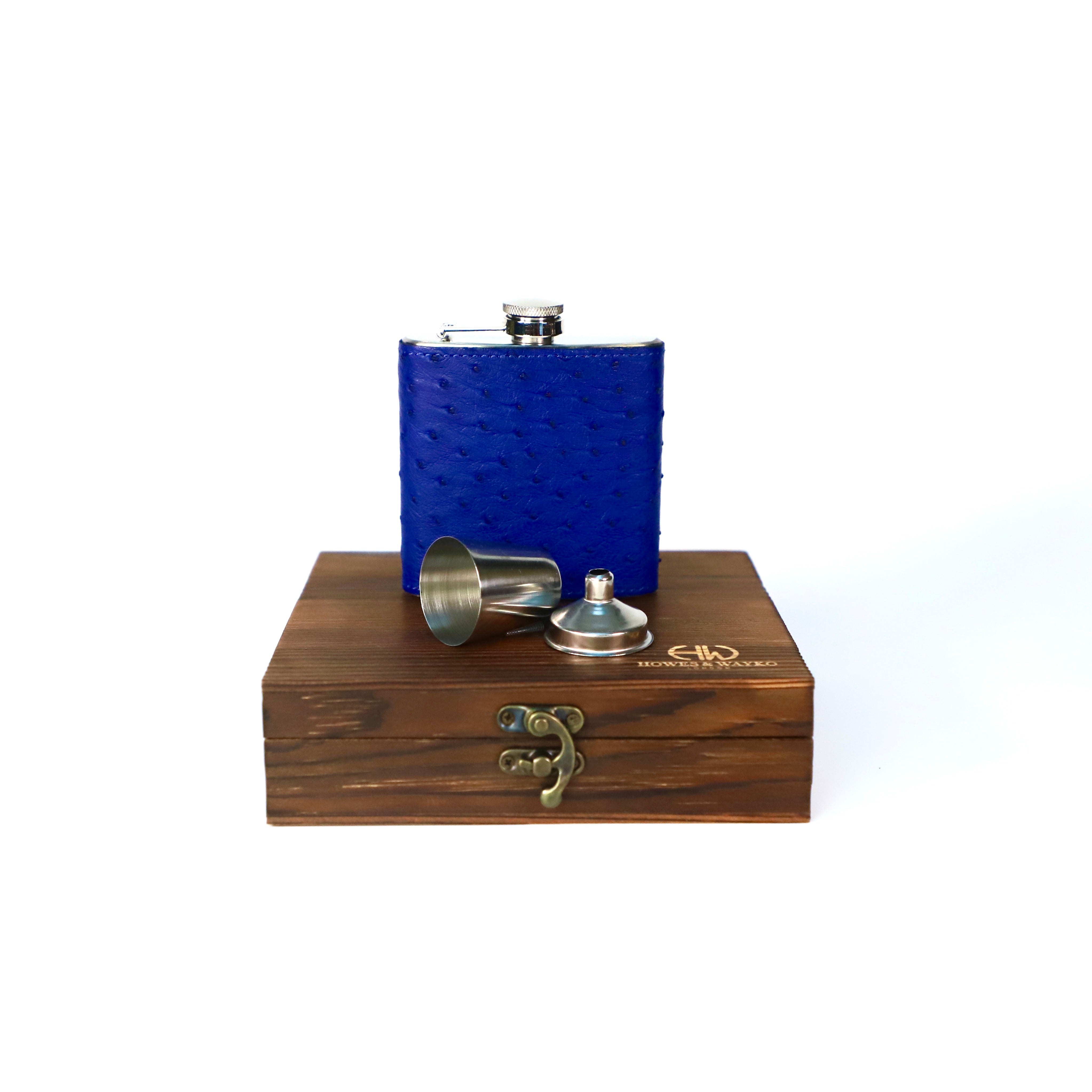 blue ostrich flask displayed on top of a dark brown wooden gift box