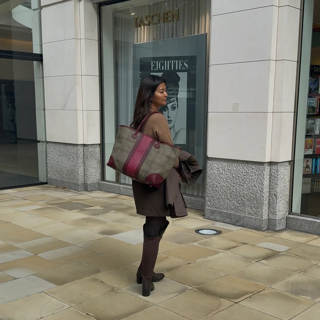 Woman holding a large Howes and Wayko yote bag in front of a store entrance
