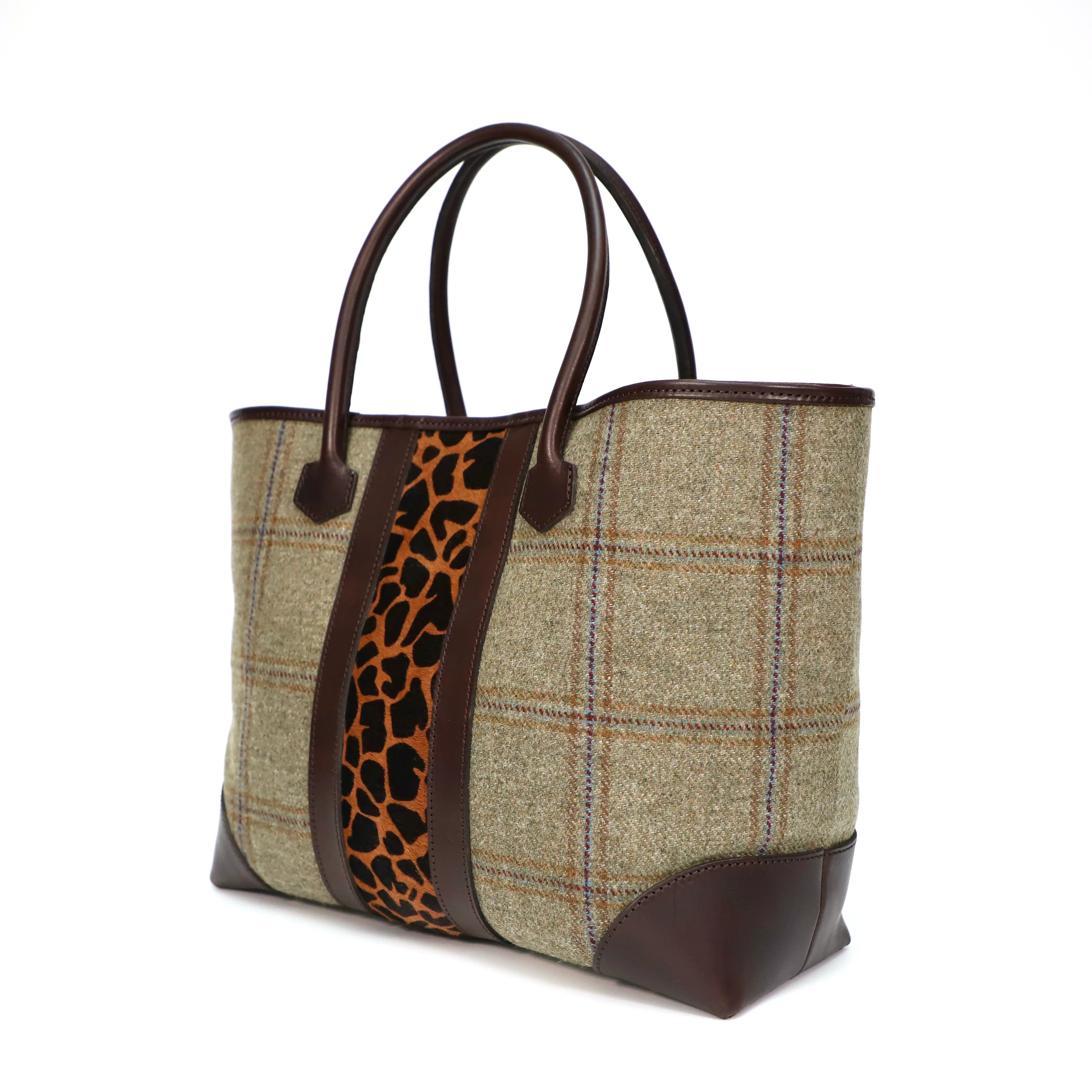 Handbag with Scottish tweed and giraffe print strap on a white background