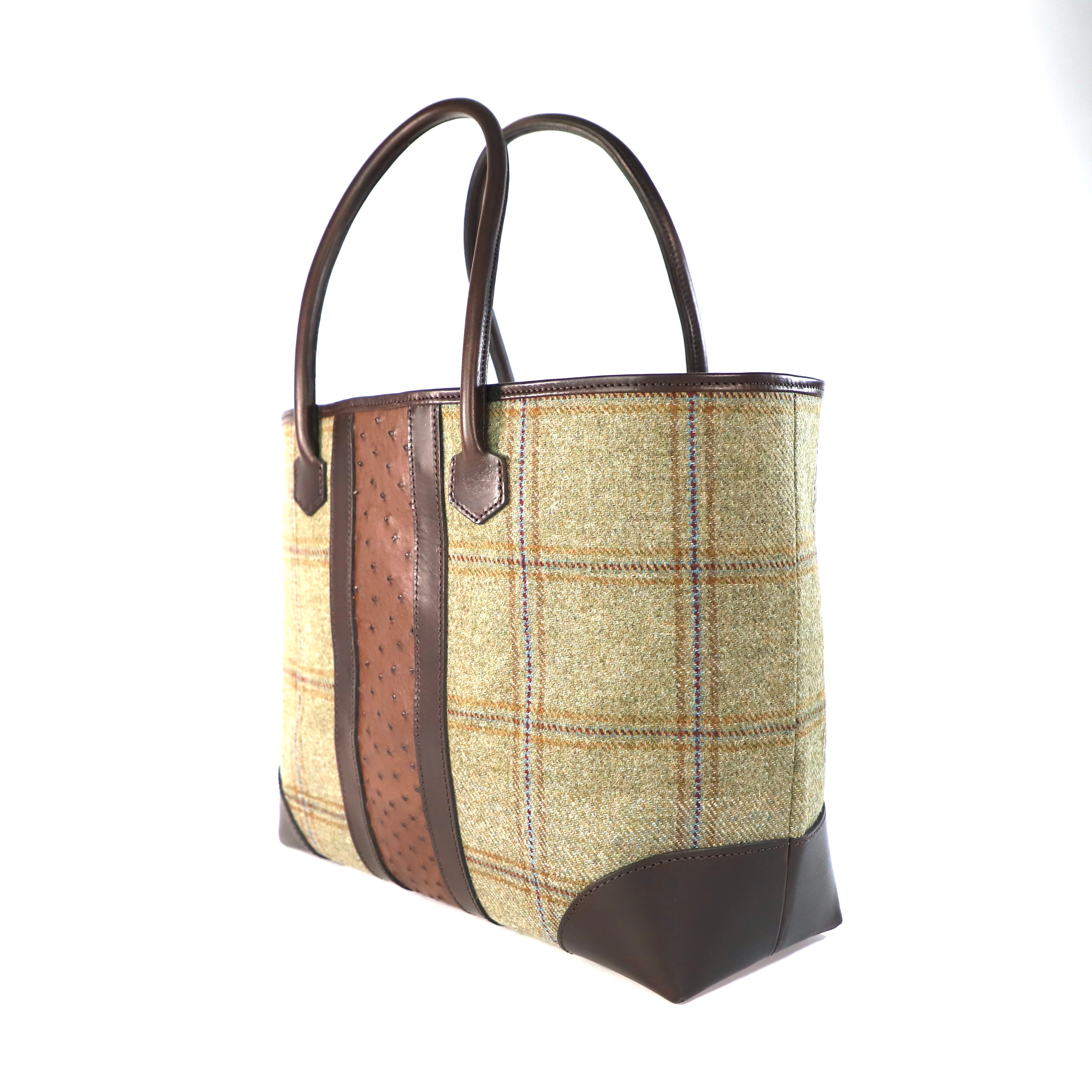 Plaid tote bag finished with brown leather and accentuated with brown Ostrich leather on a white background