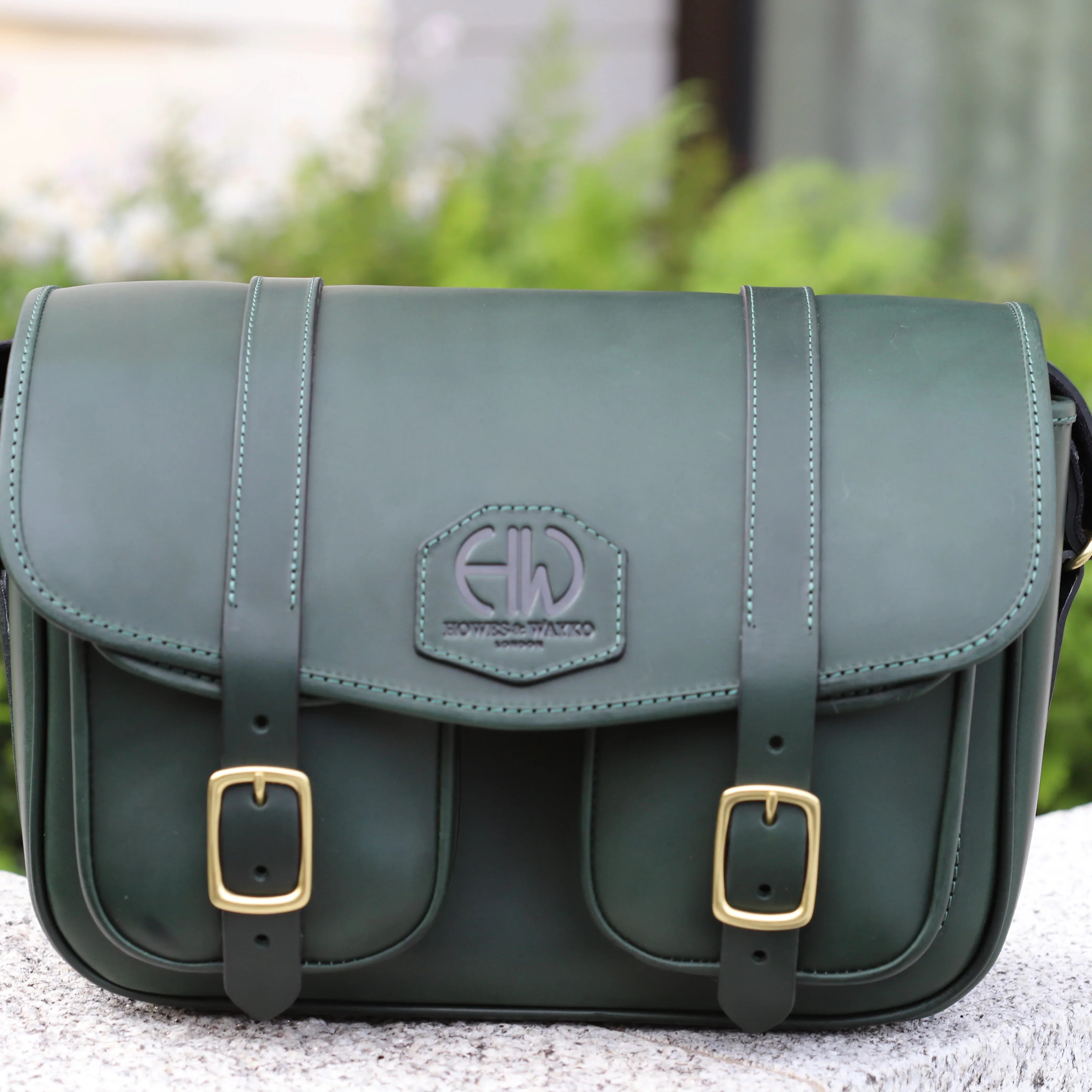 HERA-EDEN HUNTERS GREEN CARTRIDGE BAG MAIN IMAGE FRONT VIEW OF BAG PLACED ON WALL OUTDOORS