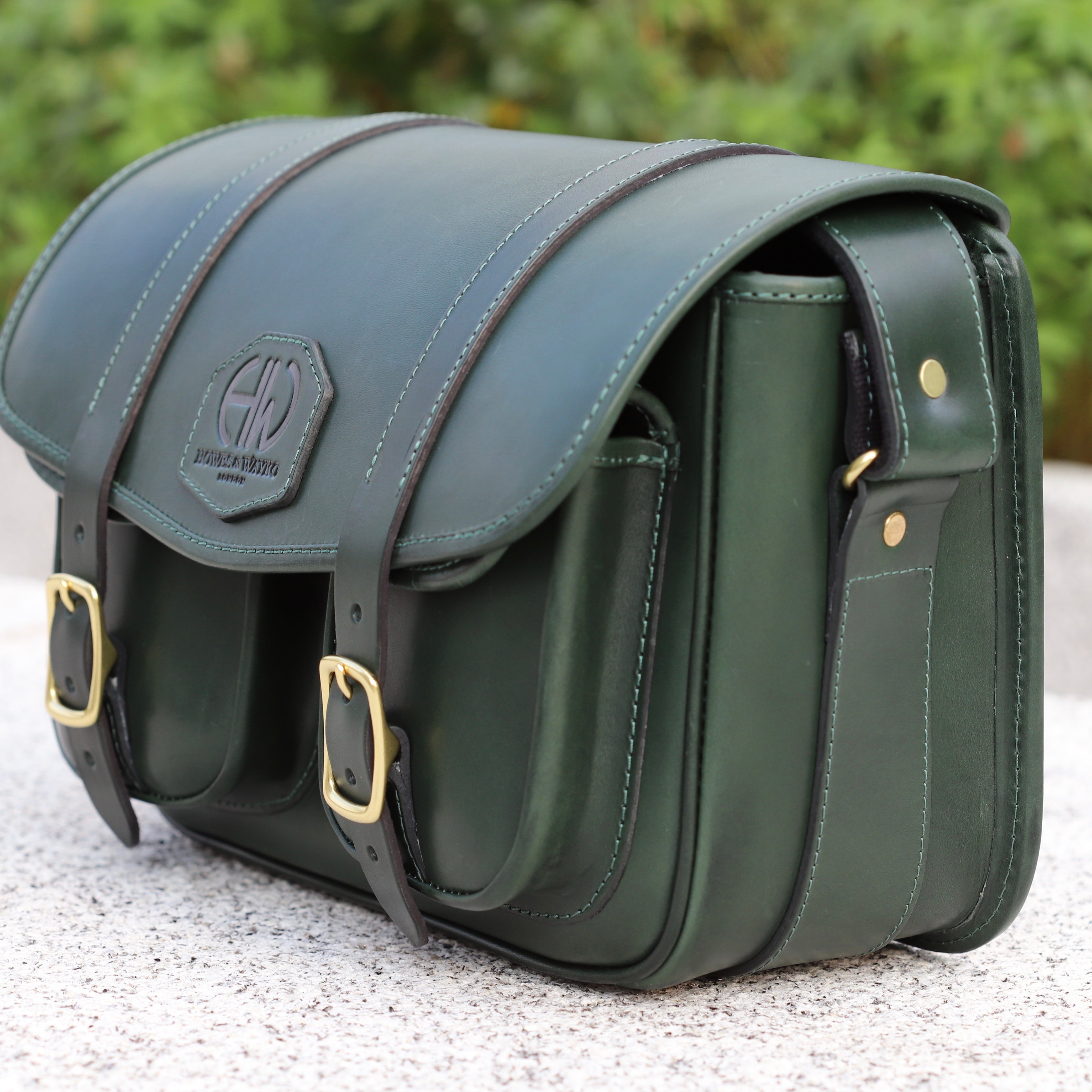 HERA-EDEN HUNTERS GREEN CARTRIDGE BAG SIDE VIEW OF BAG PLACED ON WALL OUTDOORS