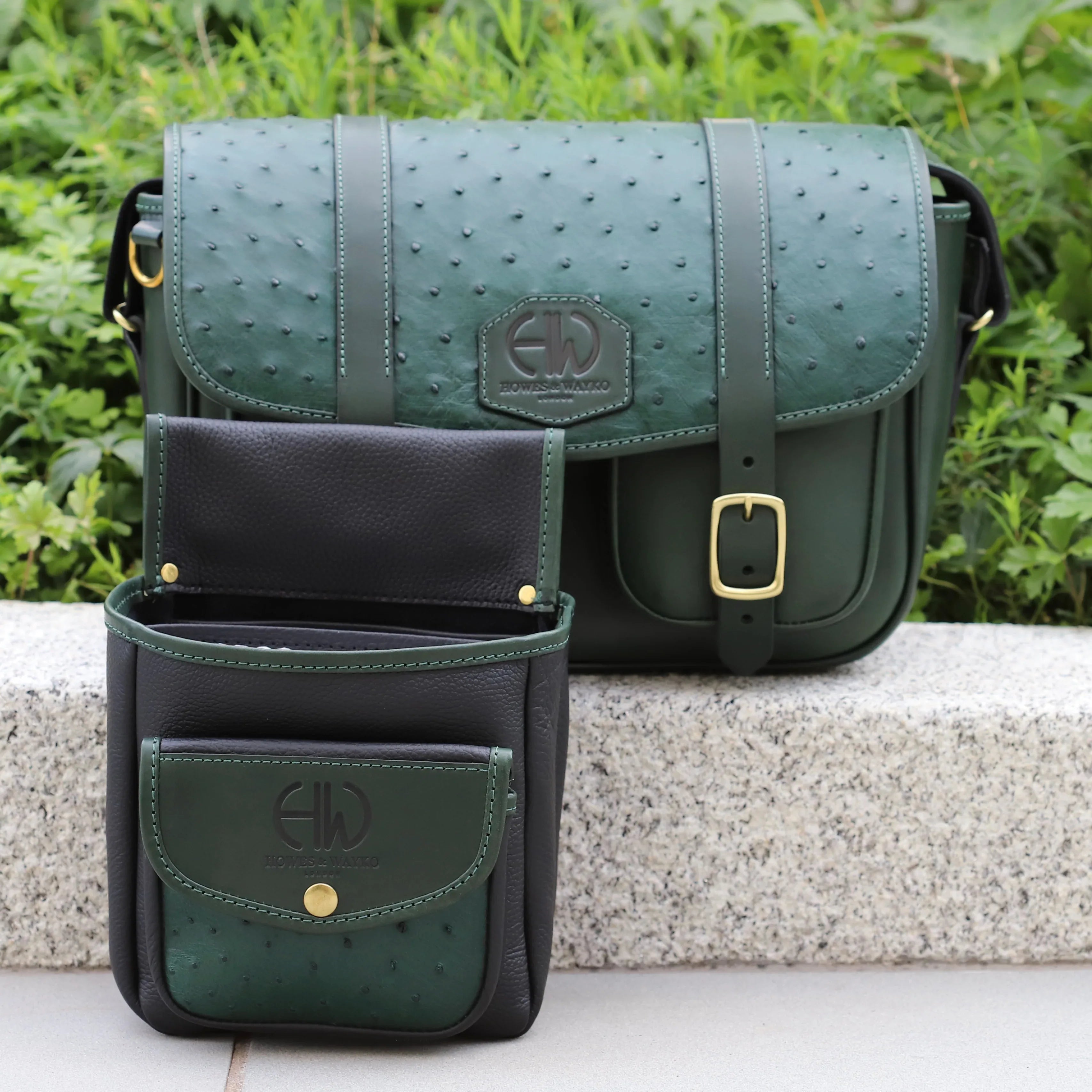 British Made Hera-Eden Green & Ostrich: Shooting Cartridge Bag front view on brick wall and matching cartridge pouch sitting in front of it