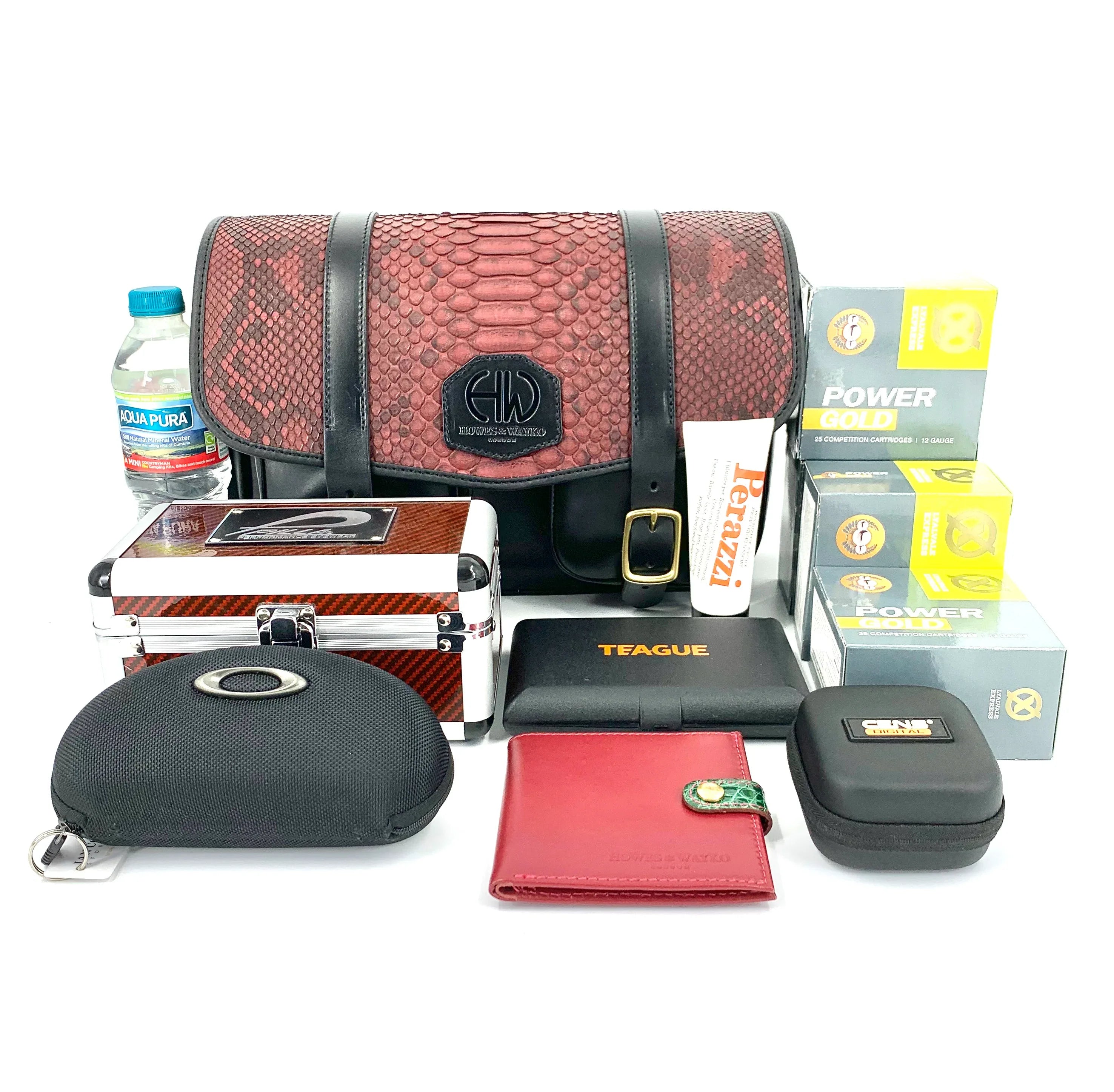 HERA-CELENE BLACK WITH BURGUNDY SNAKE CARTRIDGE BAG on a table with many other shooting accessories