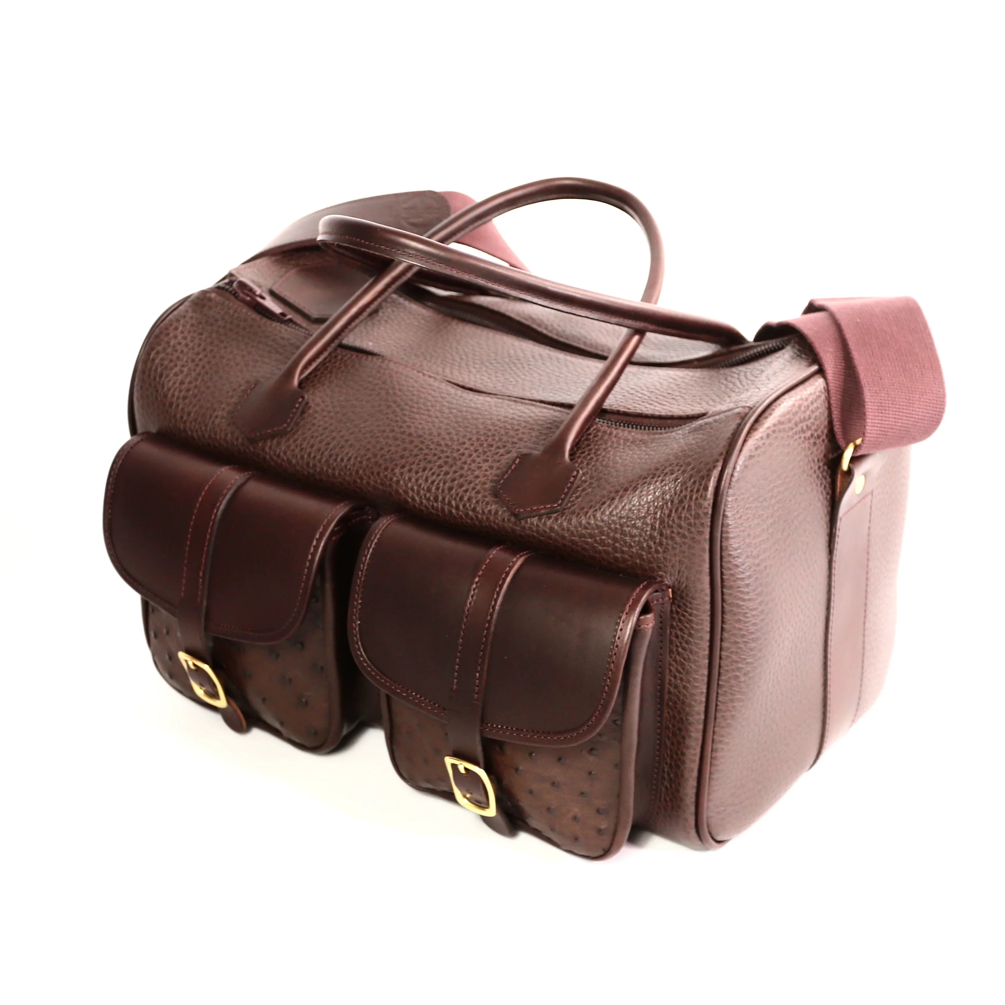 British-made Erin Brown leather bag, finished with two Ostrich pockets and a wide over-the-shoulder strap, and comfortable hand carry straps. Range Bag top side view on a white background