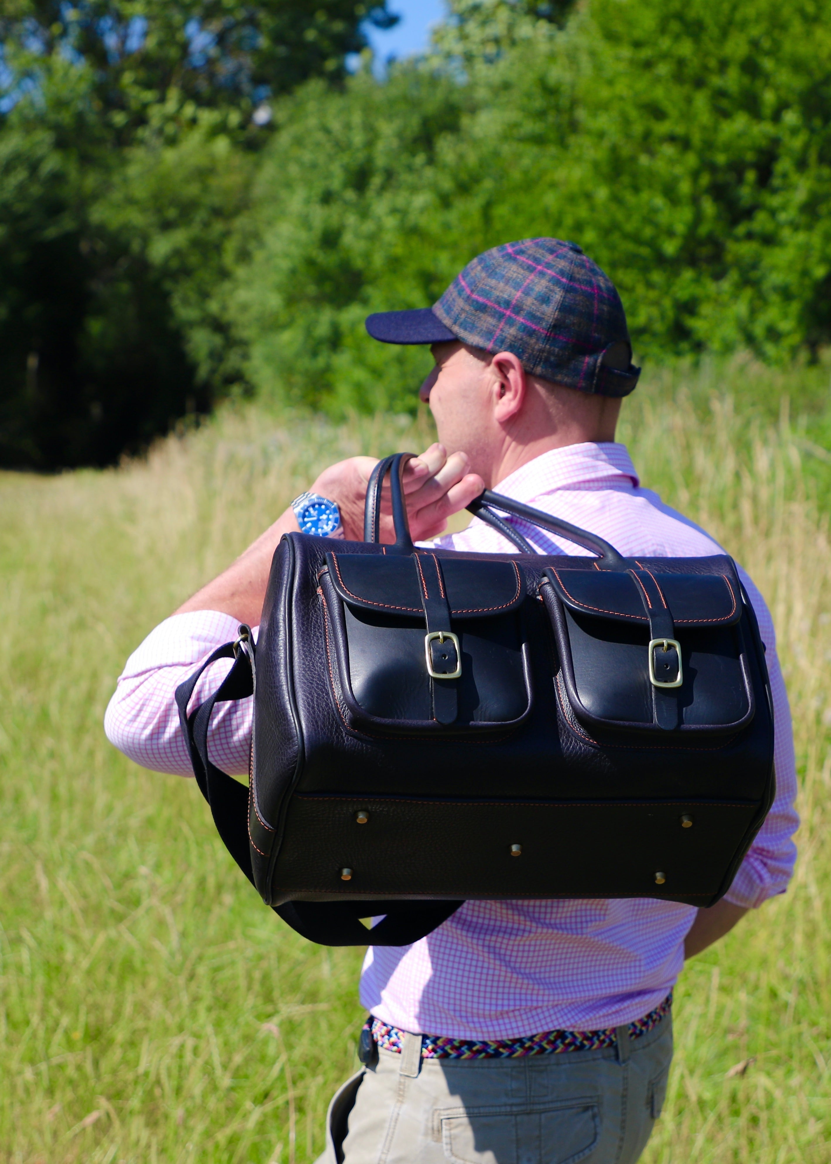 a person in the field with shooting accessories and a howes and wayko range bag