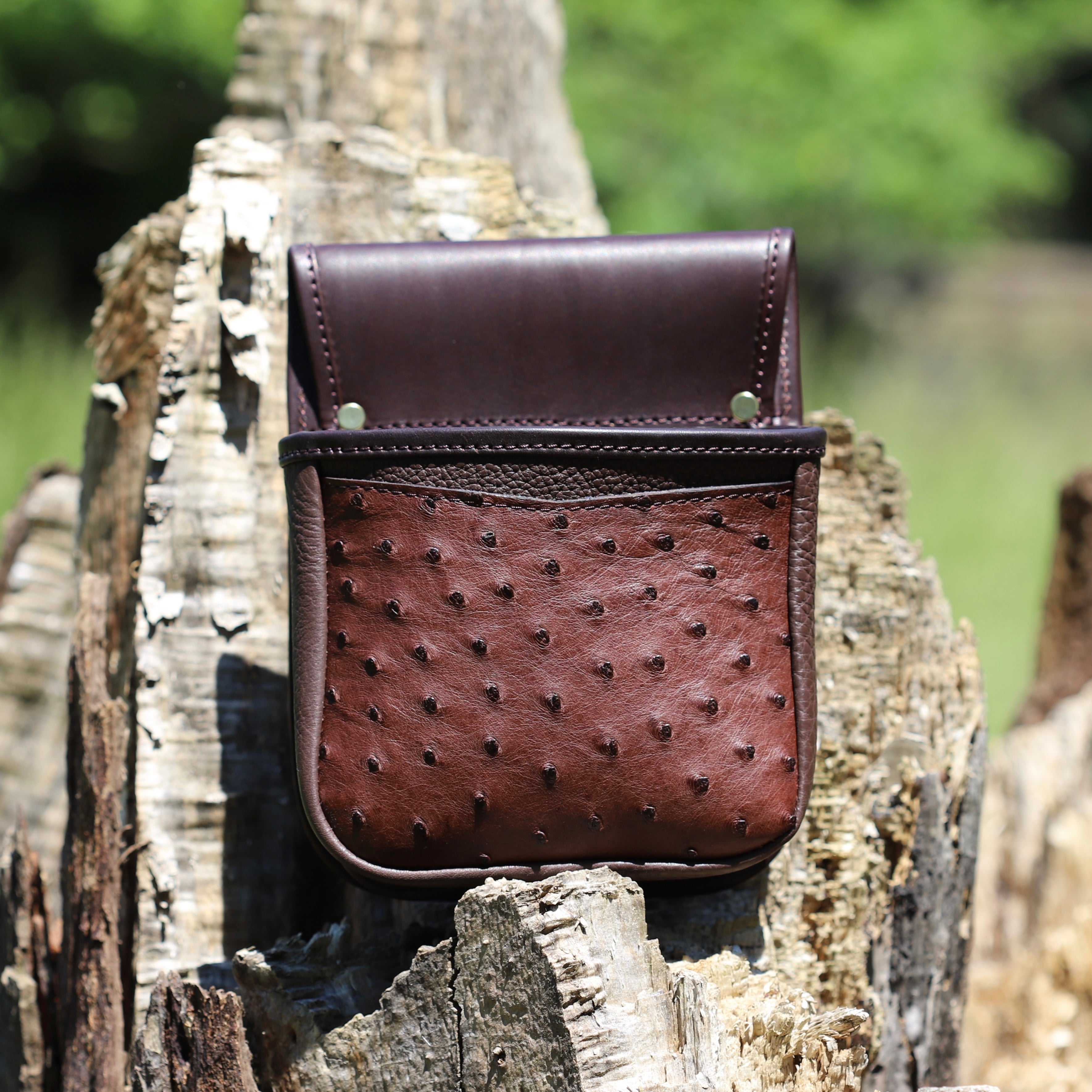 shooting pouch resting on a wooden log outdoors