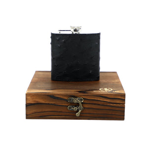 dark ostrich flask on top of wooden encasing 