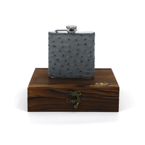 a luxury hip flask sitting on its wooden box encasing