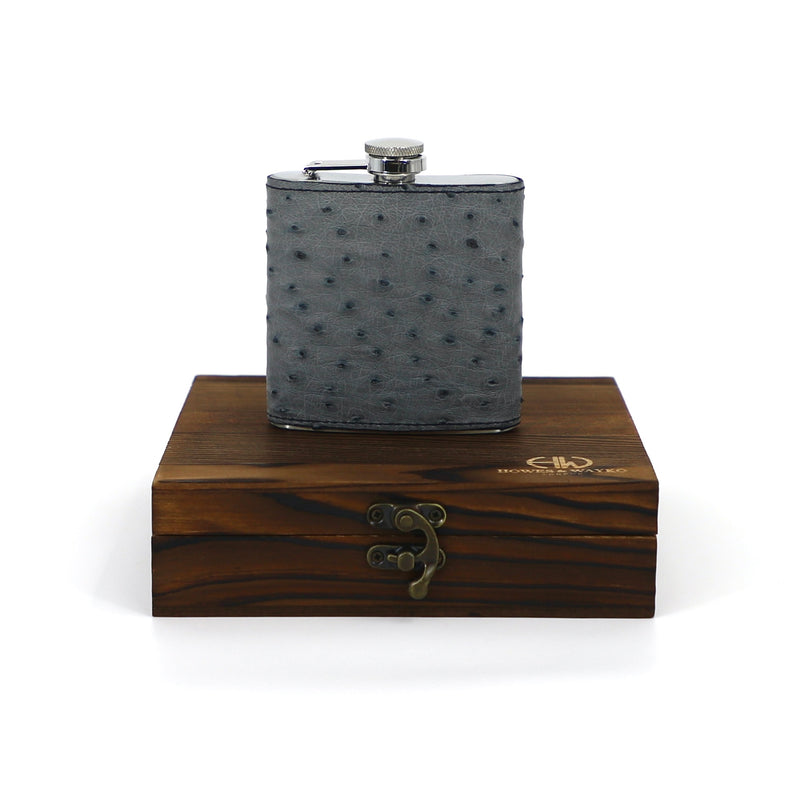 a luxury hip flask sitting on its wooden box encasing