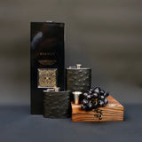 both black ostrich style hip flask sizes on with wooden case and box of whisky and grapes