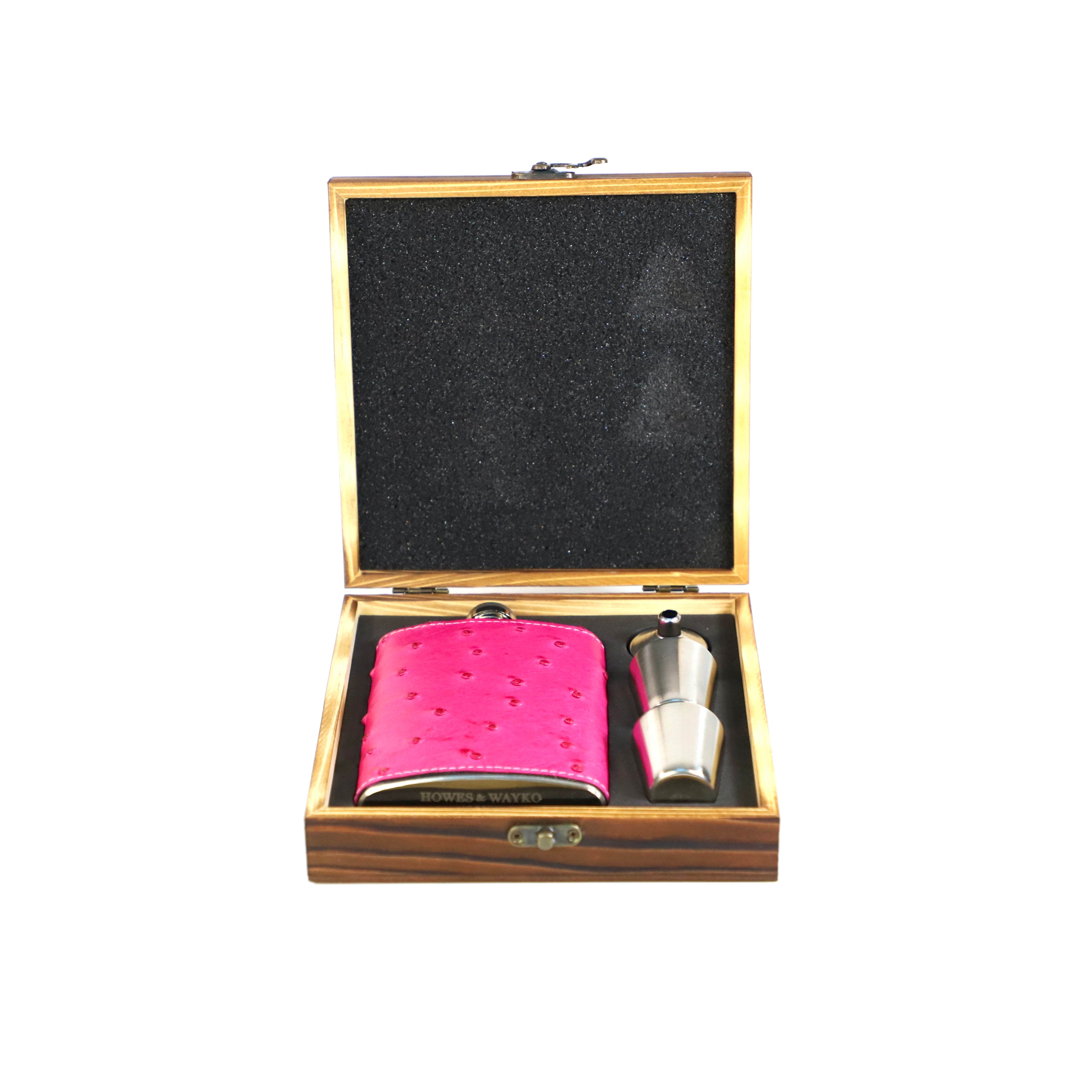 Pink leather flask and silver shaker in a wooden gift box on a white background