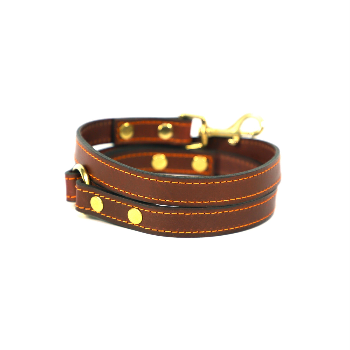 Burgundy vegetable -tanned leather Capri dog lead with yellow stitching and solid brass fittings coiled on a white back ground