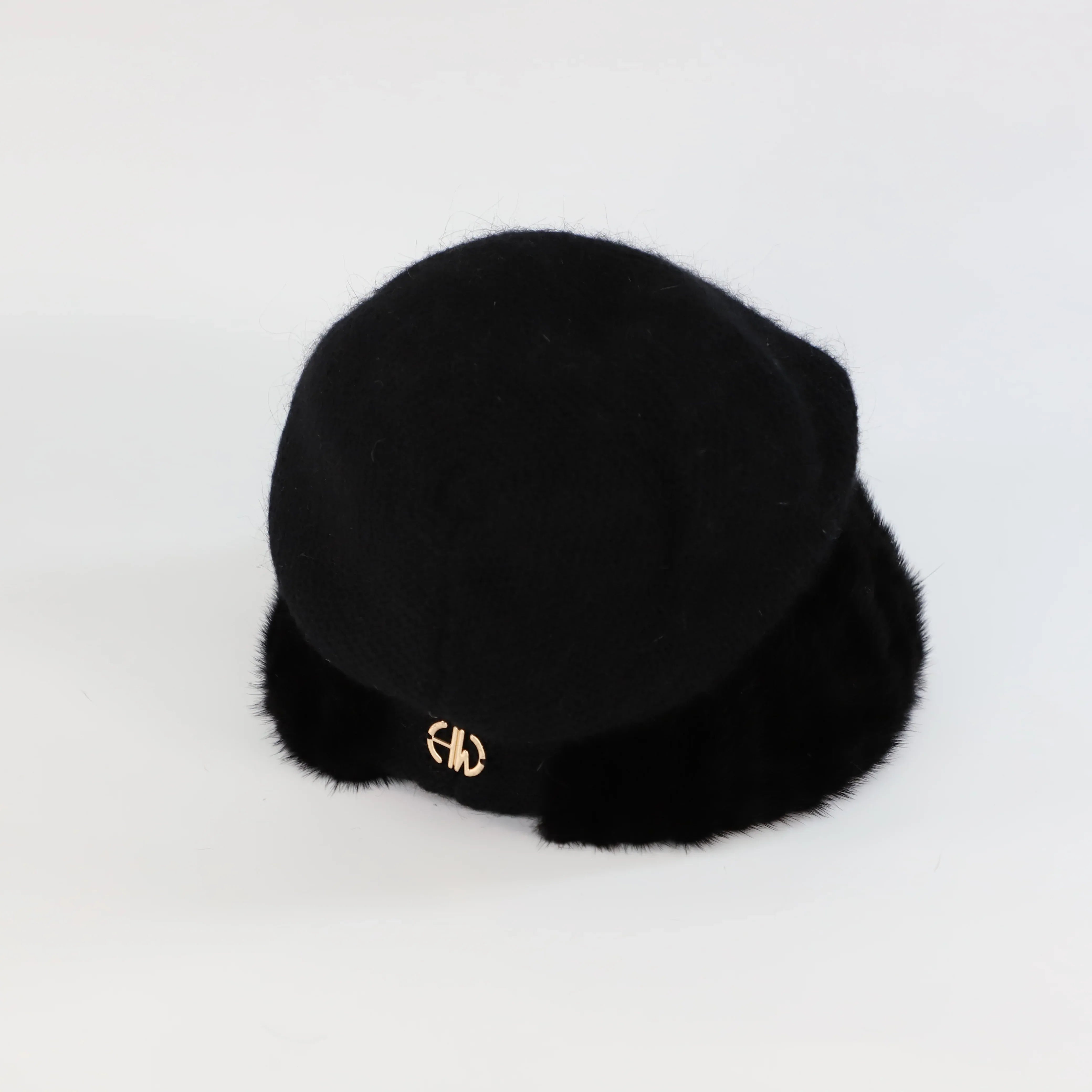 Black fur beanie hat with a gold logo on a light gray background