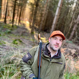 Iris Orange Shooting Baseball Cap - Shooting Gear adorned on a person in the woods and is wearing other shooting gear