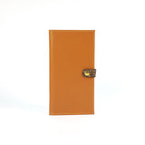 Light brown leather wallet  finished with a  brown snake clasp  and  gold snap on a white background