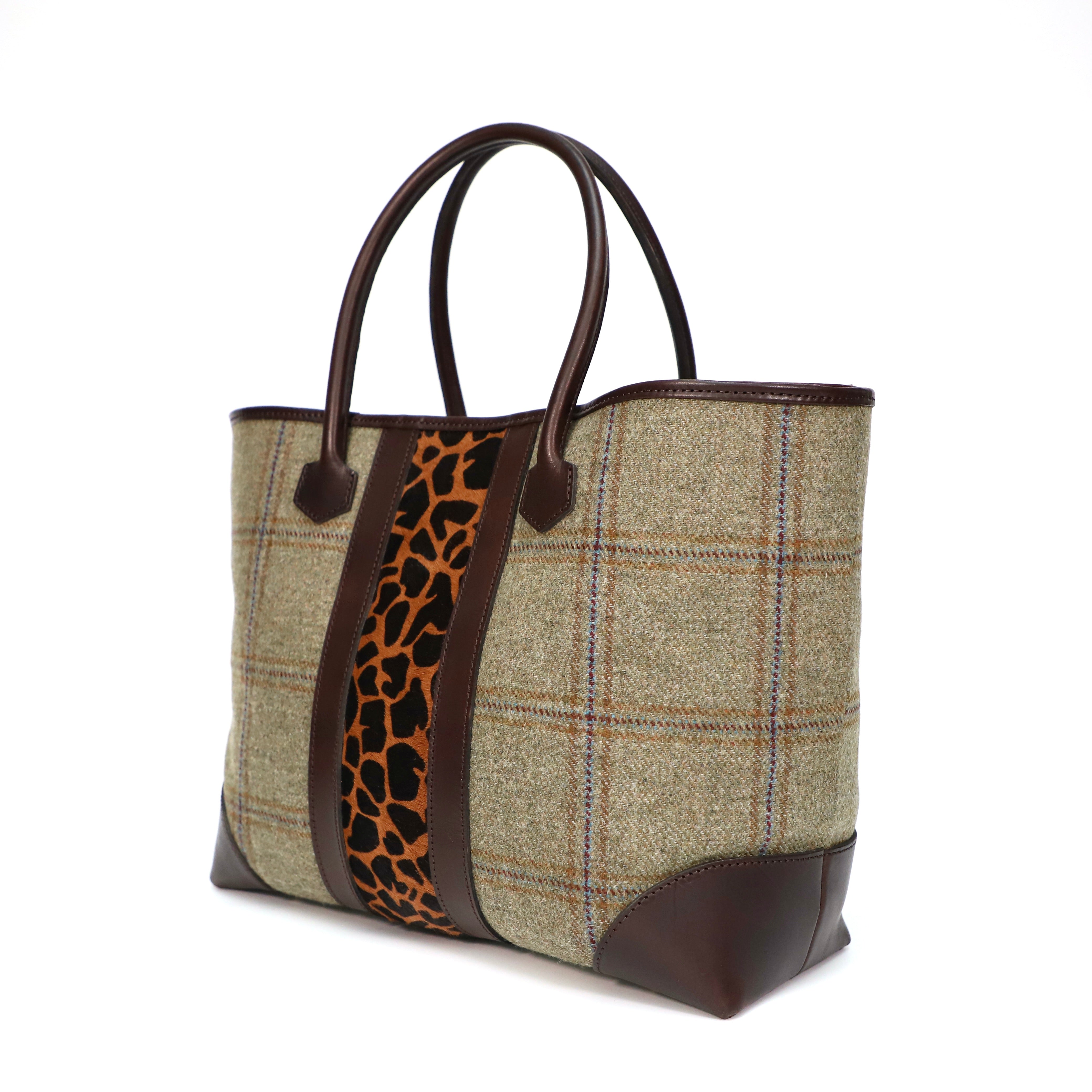 Handbag with Scottish tweed and giraffe print strap on a white background