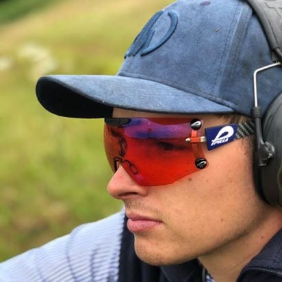 Iris Denim Blue Shooting Baseball Cap adorned on a person in the outdoors showing vibrant contrast with background greenery